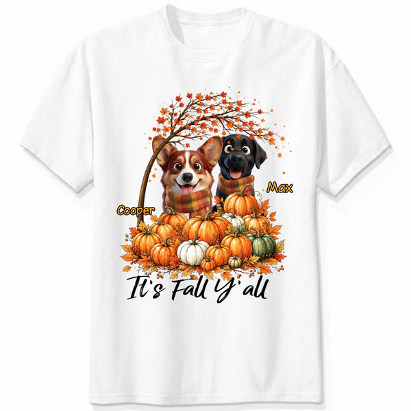 A white short-sleeve crewneck t-shirt featuring a custom autumn graphic of custom dogs sitting on a pile of pumpkins under an orange tree, with the text 'It's Fall Y'all' and custom dog's names