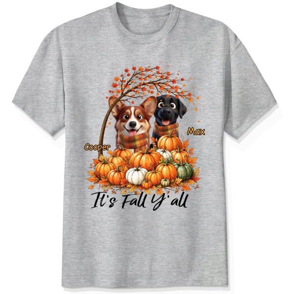 A ash grey short-sleeve crewneck t-shirt featuring a custom autumn graphic of custom dogs sitting on a pile of pumpkins under an orange tree, with the text 'It's Fall Y'all' and custom dog's names