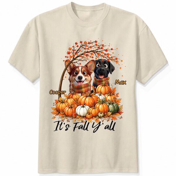 A sand short-sleeve crewneck t-shirt featuring a custom autumn graphic of custom dogs sitting on a pile of pumpkins under an orange tree, with the text 'It's Fall Y'all' and custom dog's names