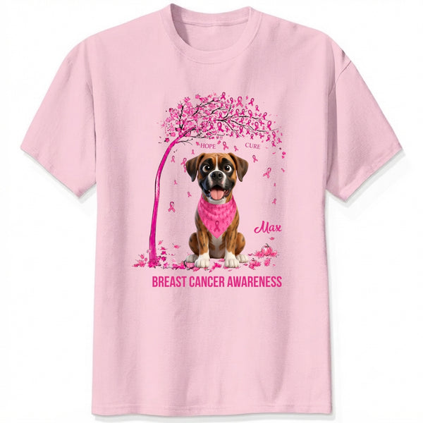 A light pink short-sleeve crewneck t-shirt featuring a graphic of dogs wearing pink bandana under a pink tree with pink ribbons, with the text 'Breast Cancer Awareness' and customized with dog's names printed below.